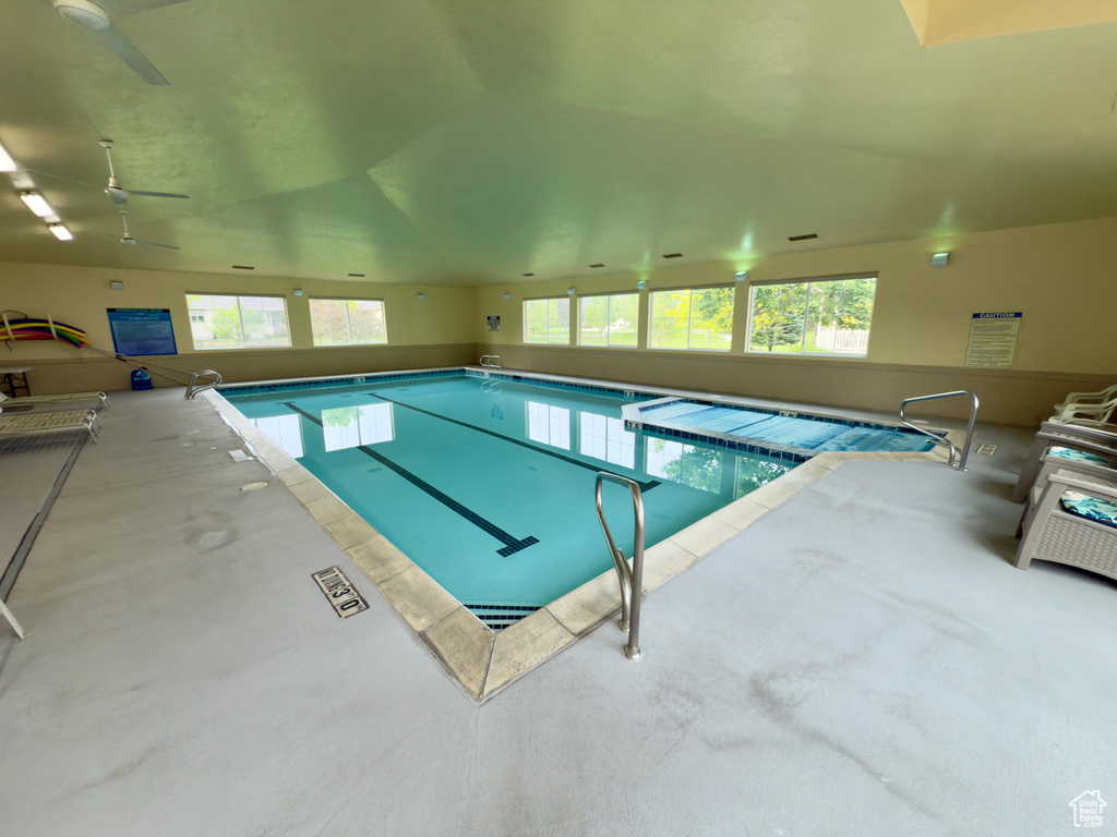 Indoor pool featuring ceiling fan