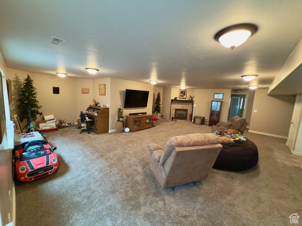 Living area with carpet floors, a fireplace, and baseboards