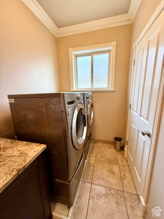 Washroom featuring crown molding, separate washer and dryer, light stone finish flooring, and baseboards