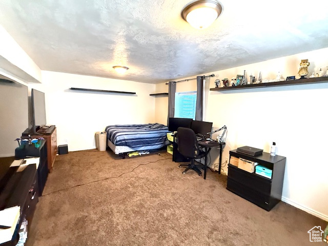 Carpeted bedroom with a desk and baseboards