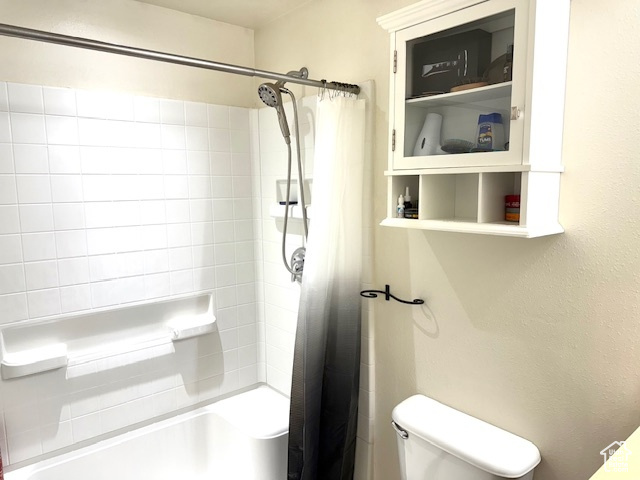 Bathroom with shower / tub combo and toilet