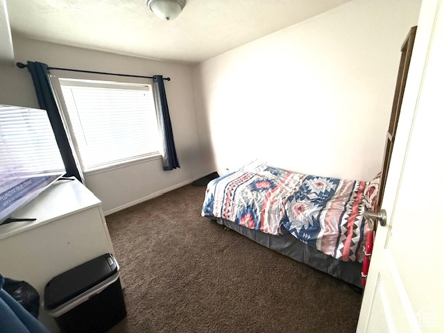 Carpeted bedroom featuring baseboards
