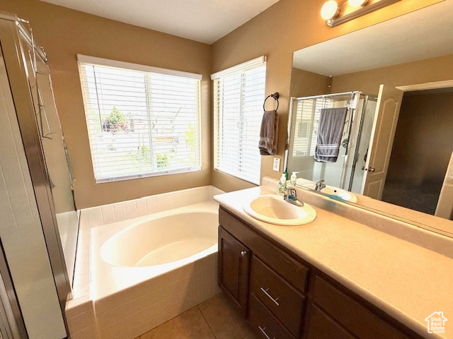 Full bath featuring a bath, vanity, tile patterned floors, and a shower stall