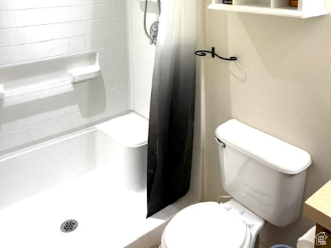 Full bathroom with a shower stall, toilet, and vanity