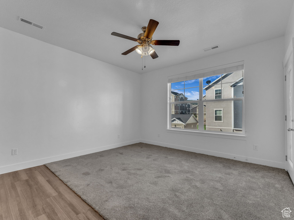 Unfurnished room with baseboards, ceiling fan, and wood finished floors