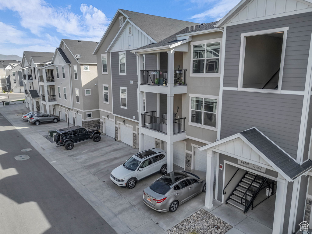View of property featuring a garage, driveway, and a residential view