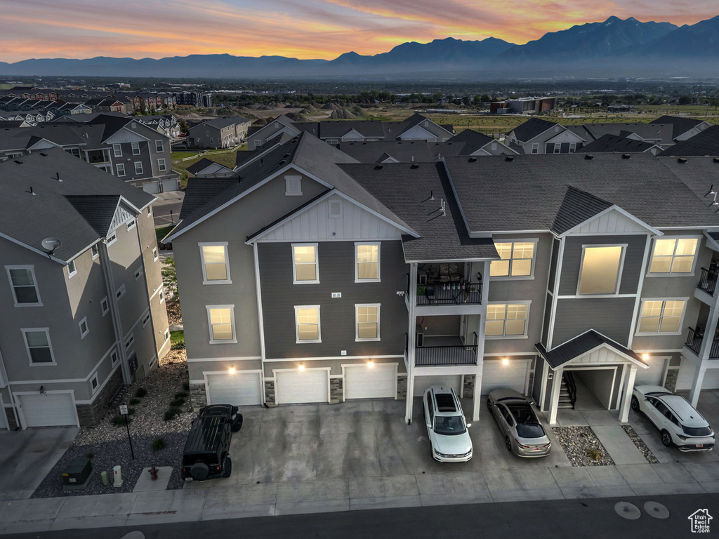 Aerial view of property and surrounding area featuring a mountainous background