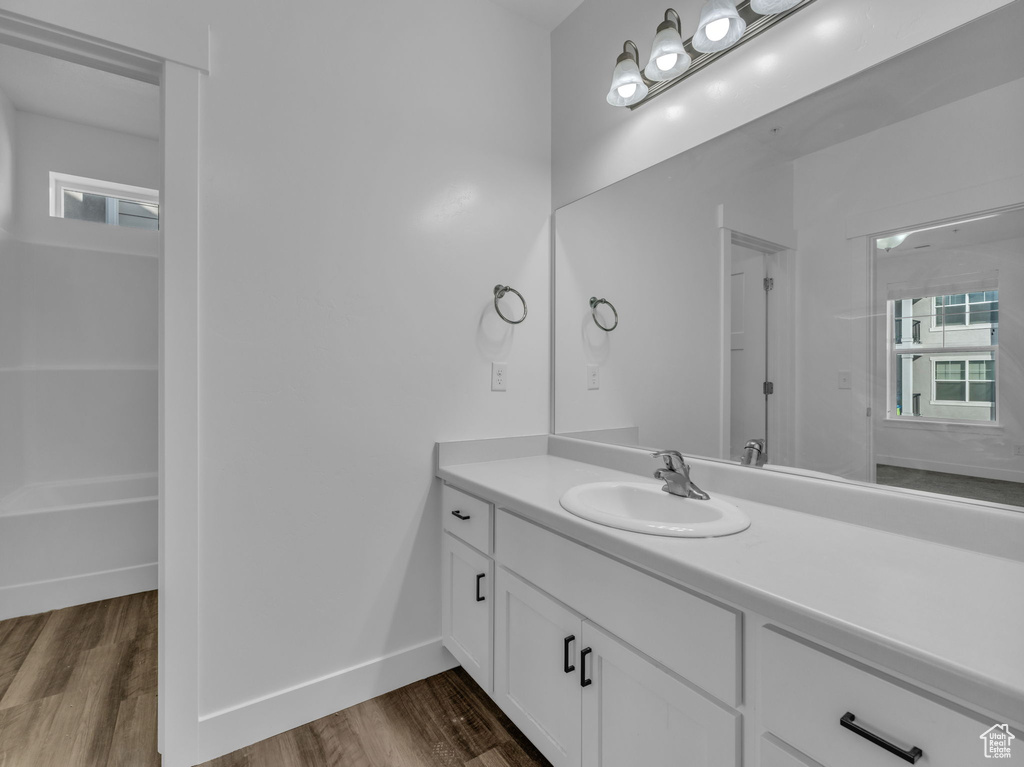 Bathroom featuring vanity, wood finished floors, and baseboards