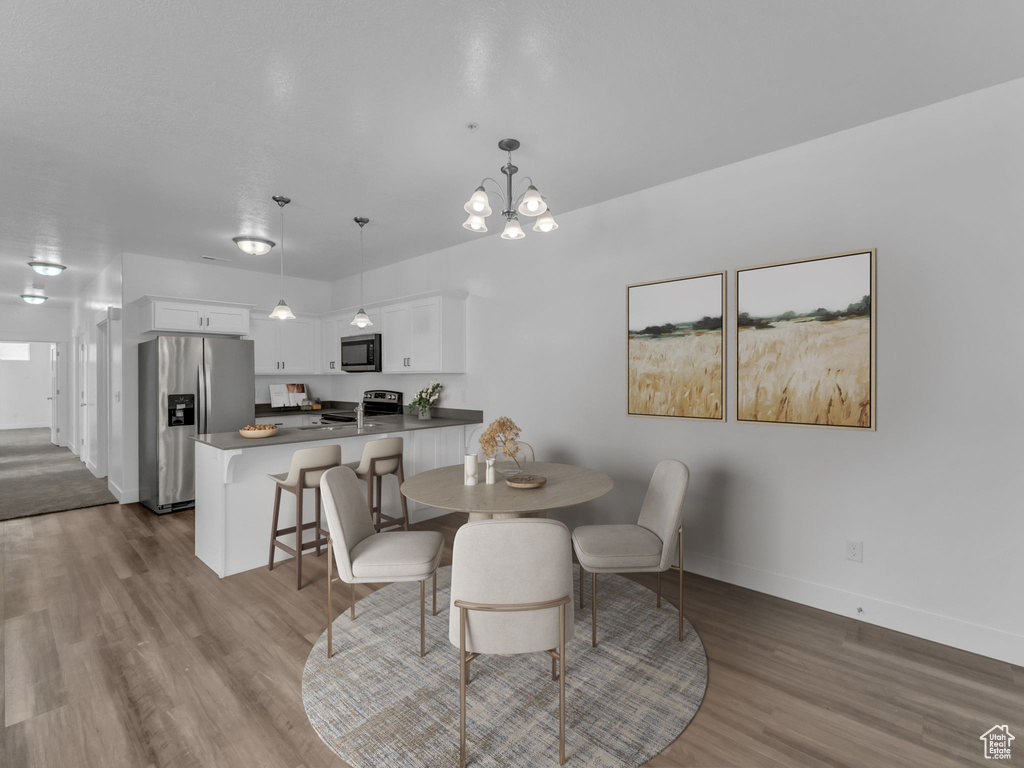 Dining area with dark wood finished floors, baseboards, and a chandelier