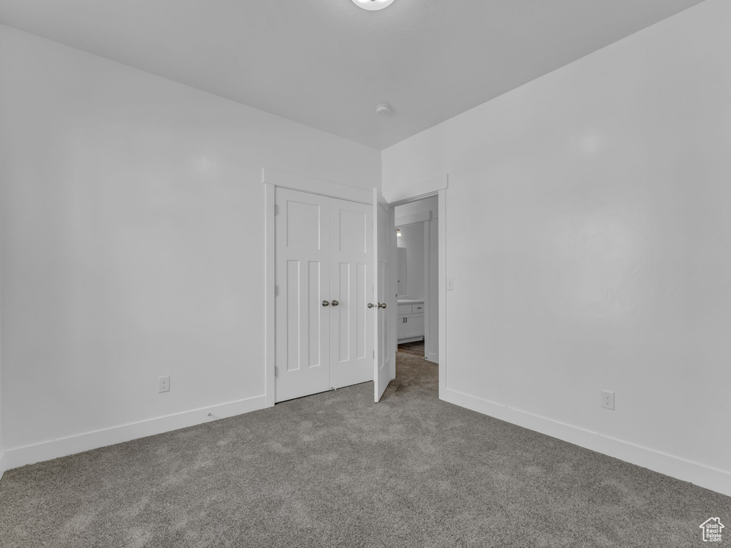 Unfurnished bedroom featuring carpet, baseboards, and a closet