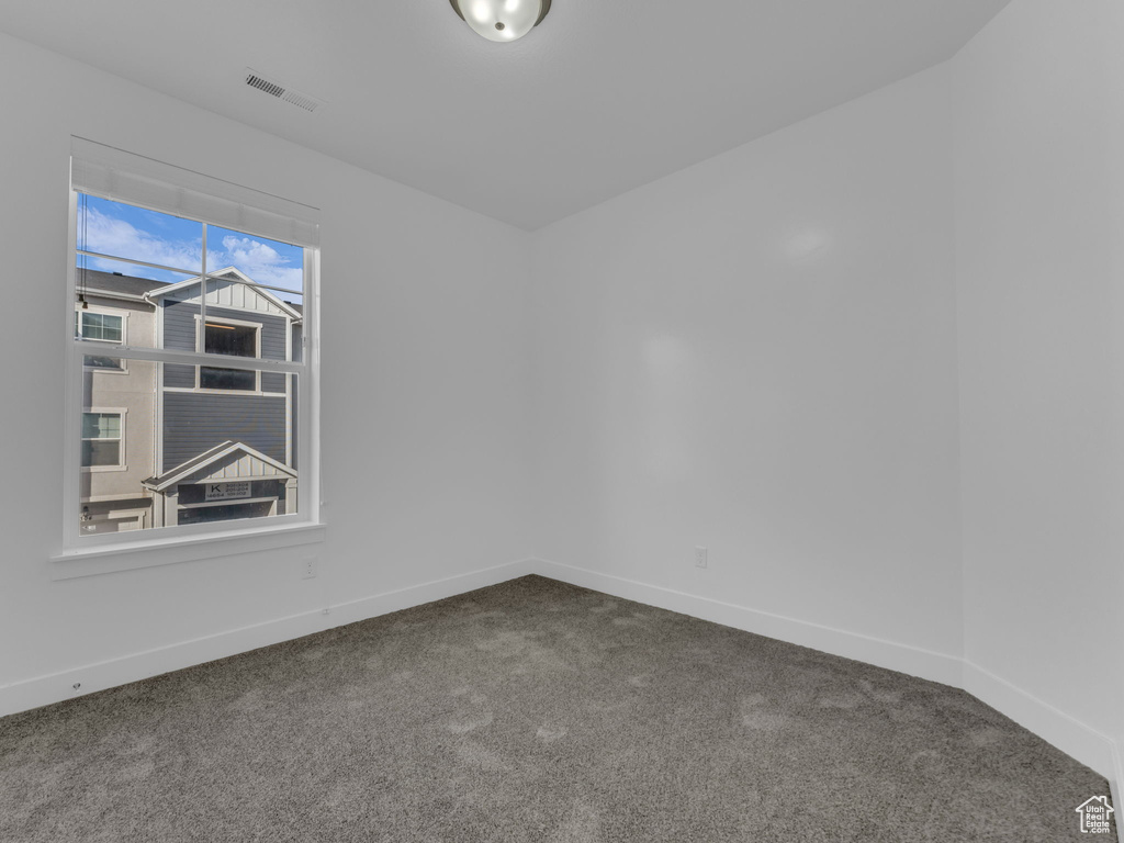Carpeted spare room with baseboards