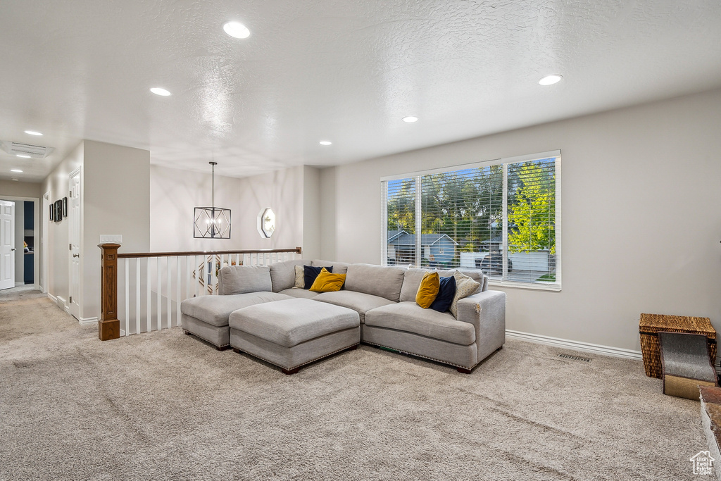 Living room featuring carpet flooring, recessed lighting, a chandelier, and baseboards