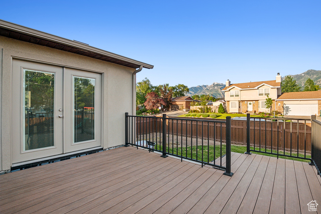 Wooden deck featuring a mountain view, a residential view, and french doors