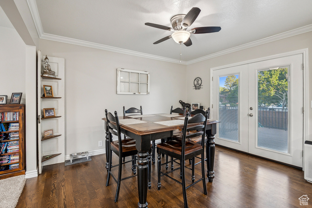 Dining room featuring french doors, dark wood finished floors, a ceiling fan, ornamental molding, and baseboards