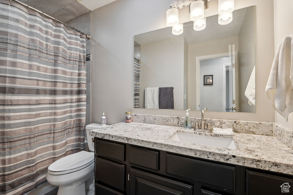 Bathroom with vanity, toilet, and a shower with curtain