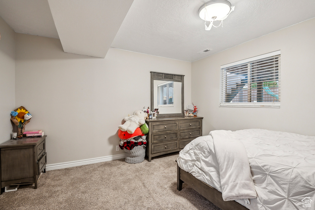 Bedroom with multiple windows, carpet flooring, and baseboards