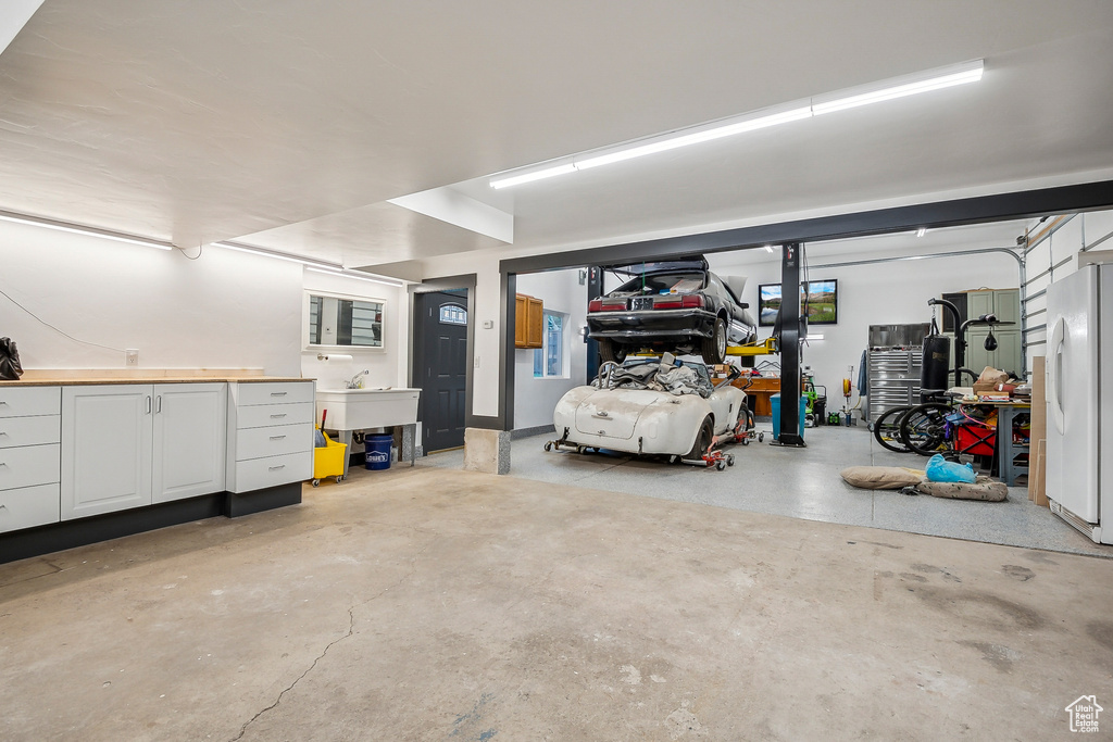 Garage with freestanding refrigerator and a sink