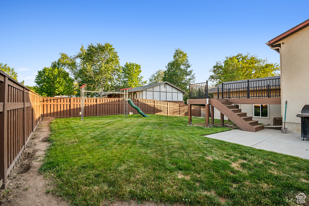 View of yard with a playground, stairs, and a patio area