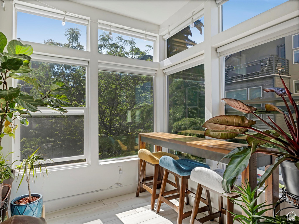 Sunroom with plenty of natural light, tile patterned floors, and a high ceiling