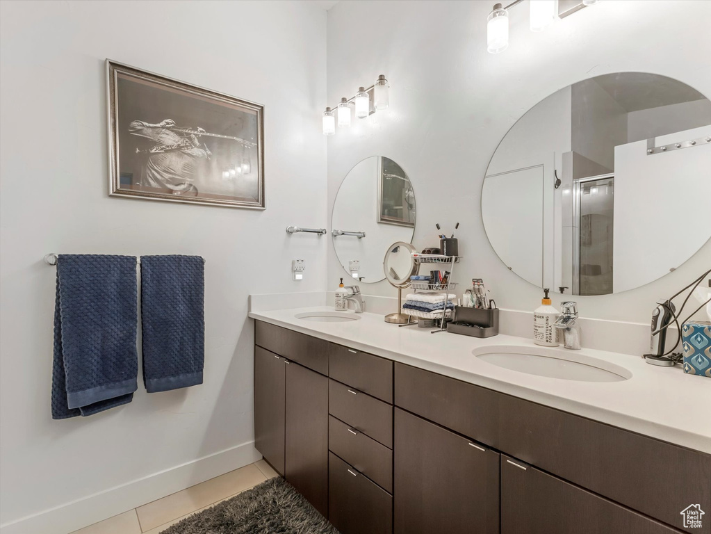 Bathroom with double vanity, tile patterned flooring, a stall shower, and baseboards