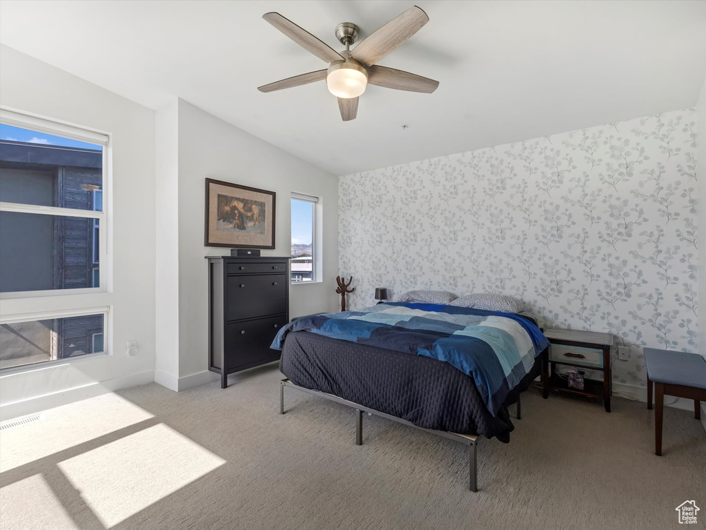 Bedroom featuring wallpapered walls, light colored carpet, baseboards, ceiling fan, and vaulted ceiling