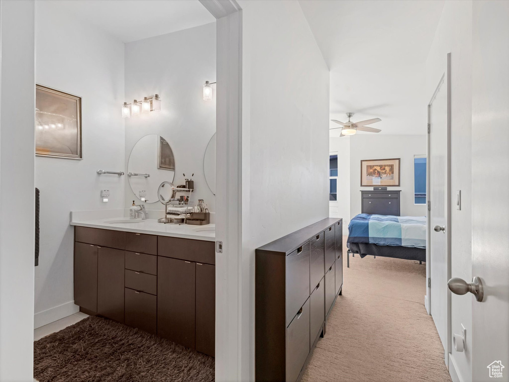 Bathroom featuring double vanity, connected bathroom, and ceiling fan