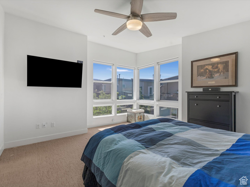 Carpeted bedroom featuring baseboards and ceiling fan