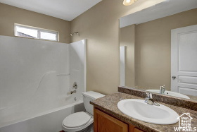 Bathroom with vanity, toilet, and bathtub / shower combination