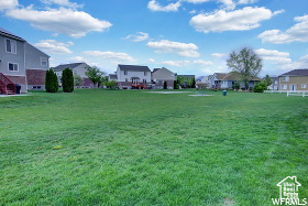 View of green lawn with a residential view