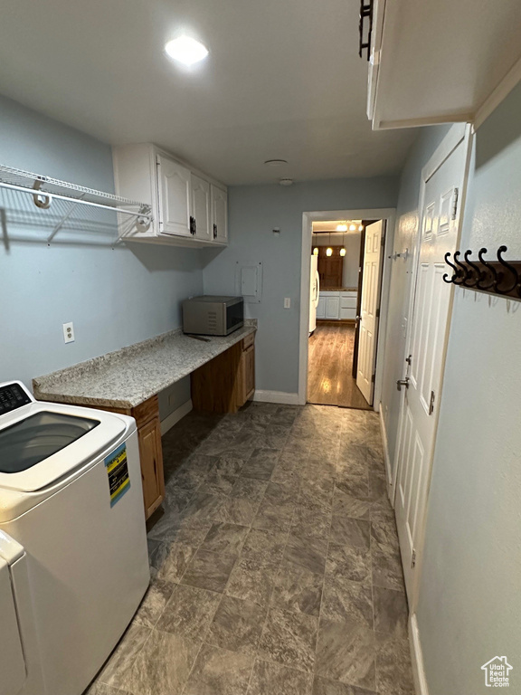 Laundry room with cabinet space, baseboards, and washing machine and clothes dryer