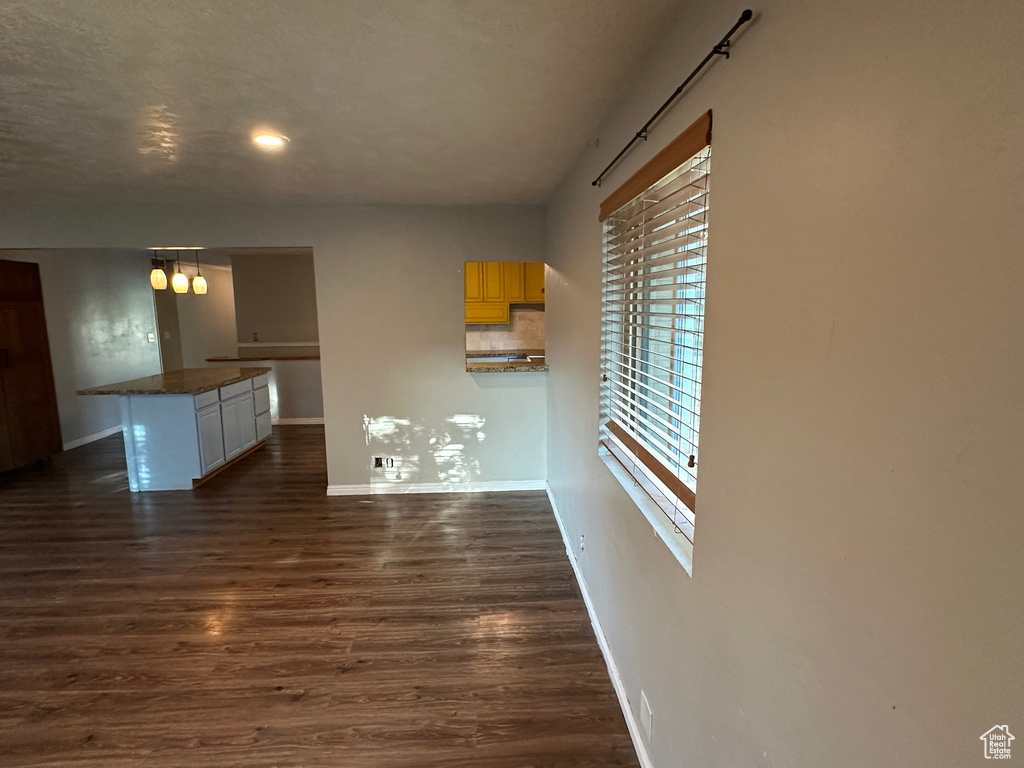 Unfurnished living room with baseboards, dark wood-style flooring, and recessed lighting