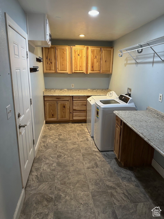 Laundry area featuring cabinet space, separate washer and dryer, baseboards, stone finish flooring, and recessed lighting