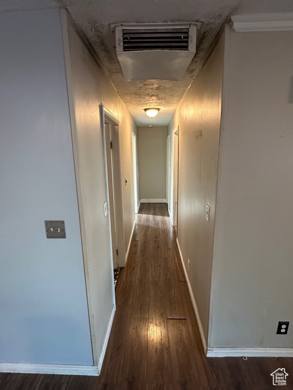 Hallway with wood finished floors, baseboards, and attic access