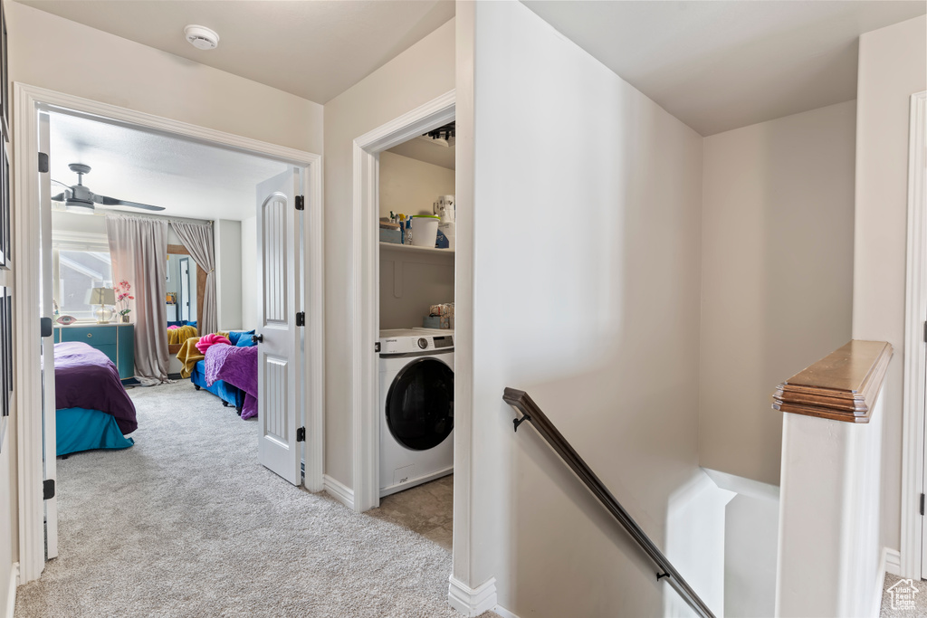 Hall featuring washer / dryer, an upstairs landing, carpet, and baseboards