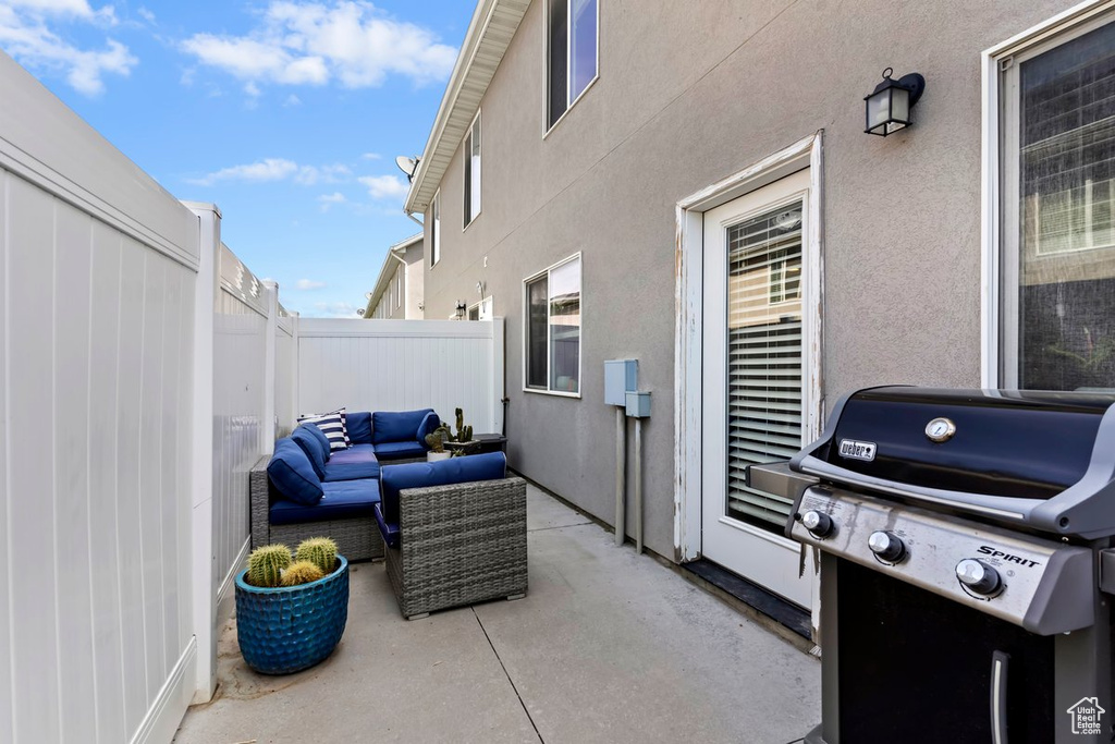 Fenced backyard featuring an outdoor hangout area, a patio, and a grill