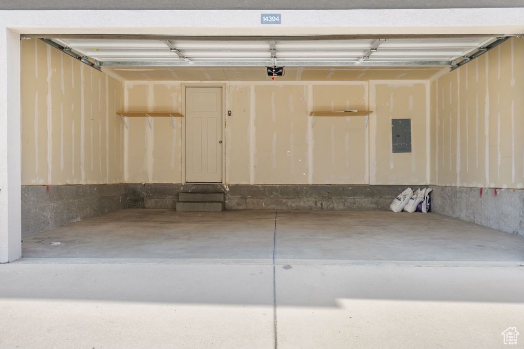 Garage featuring electric panel and a garage door opener