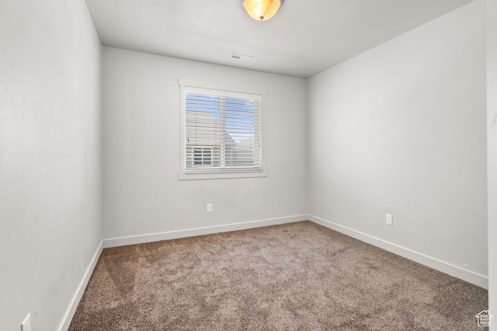 Carpeted empty room with baseboards