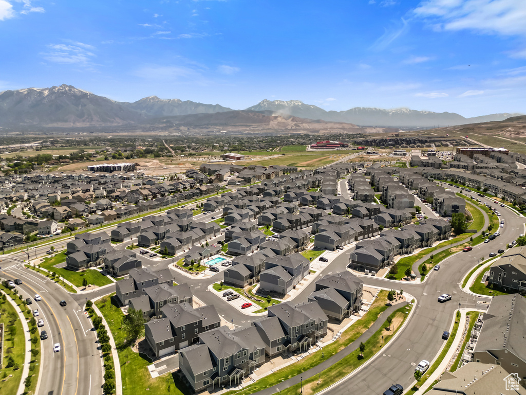 Aerial view of property and surrounding area featuring nearby suburban area and a mountainous background