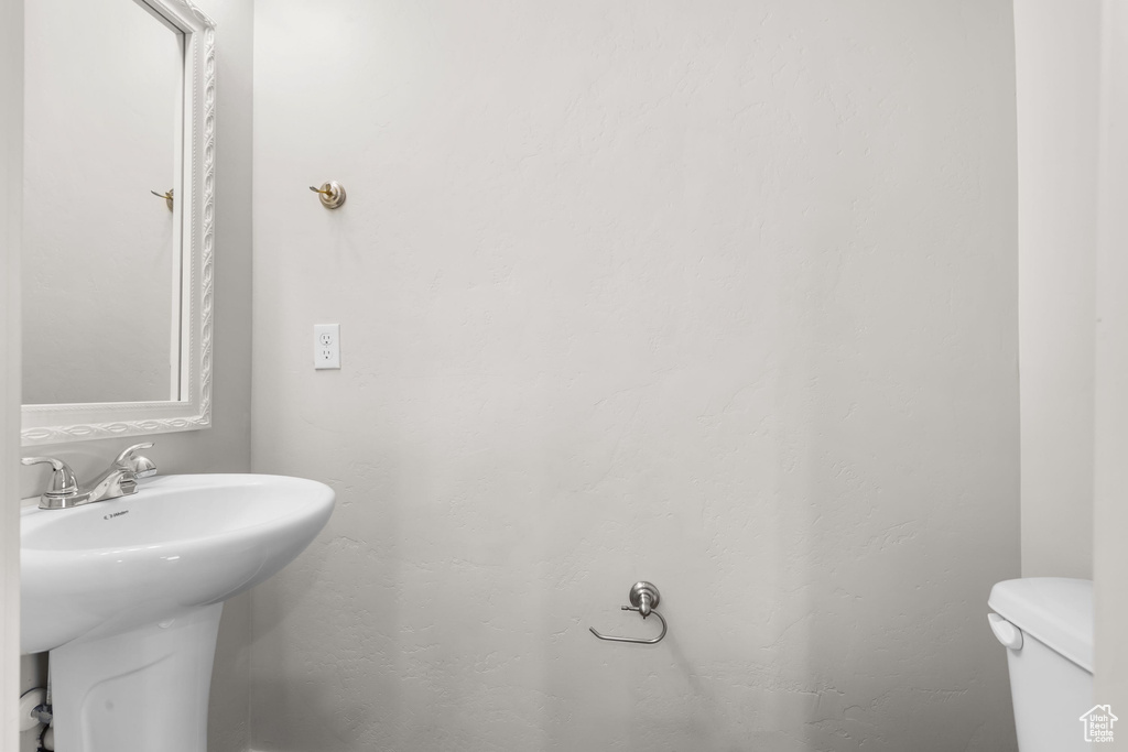 Half bath featuring toilet and a sink