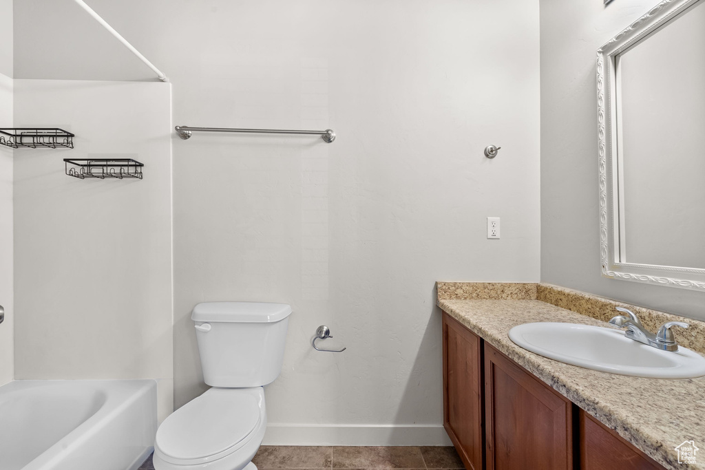 Bathroom with vanity, toilet, and baseboards