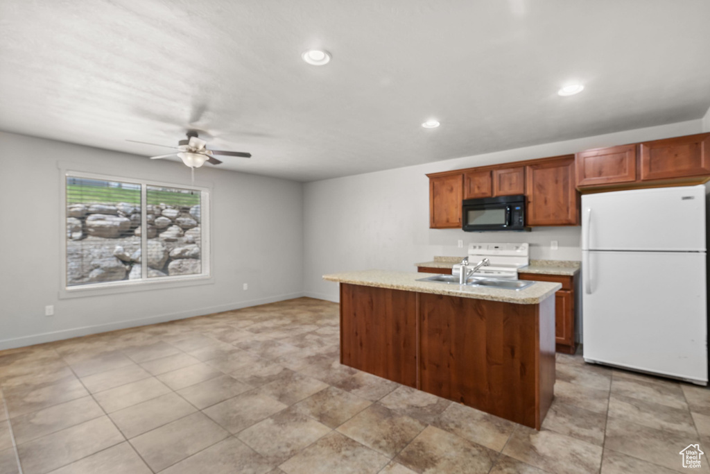 Kitchen featuring white appliances, ceiling fan, recessed lighting, baseboards, and a sink