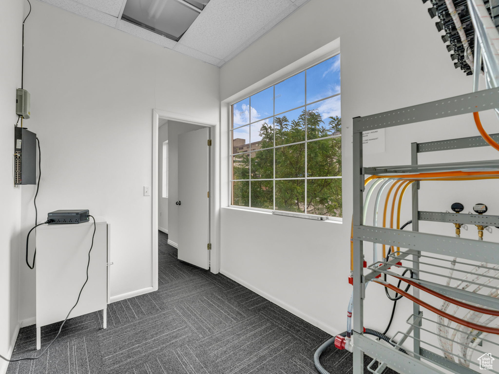 Interior space featuring dark colored carpet and baseboards