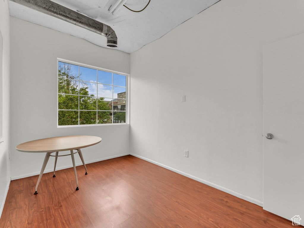 Unfurnished room with wood finished floors and baseboards