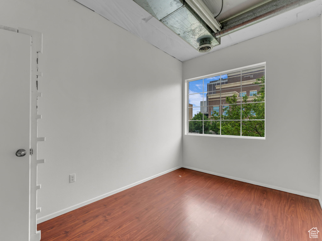 Unfurnished room with wood finished floors and baseboards
