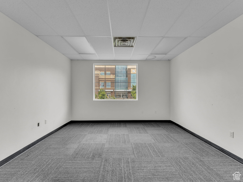 Unfurnished room with carpet floors, a paneled ceiling, and baseboards