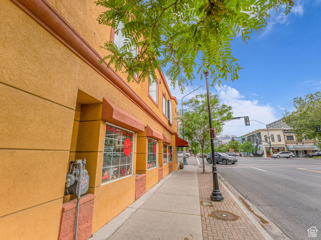 View of asphalt street with sidewalks, street lights, curbs, traffic lights, and traffic signs