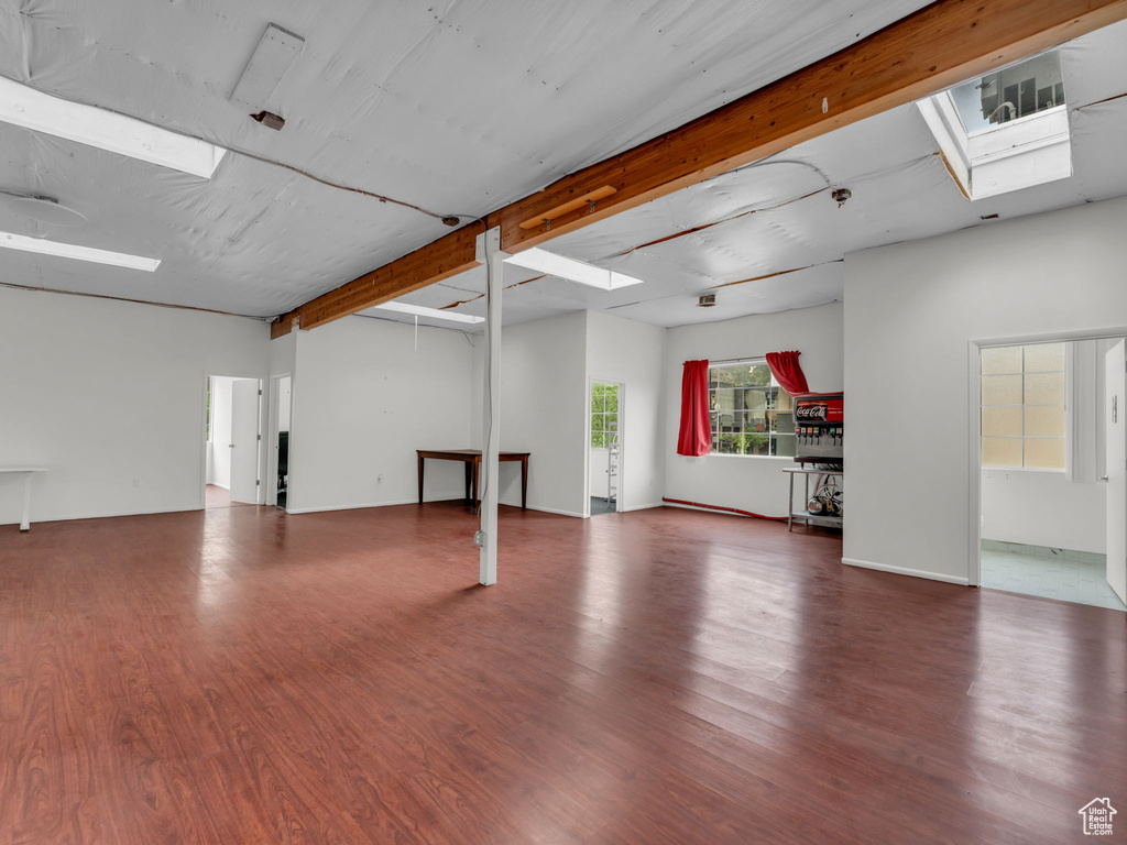 Interior space featuring wood finished floors, beamed ceiling, and a skylight
