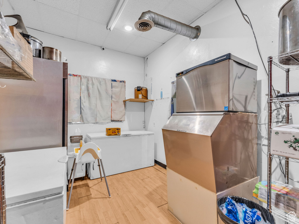 Misc room with a drop ceiling, wood finished floors, and pet washing area