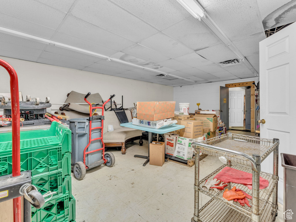Below grade area with a drop ceiling and tile patterned floors