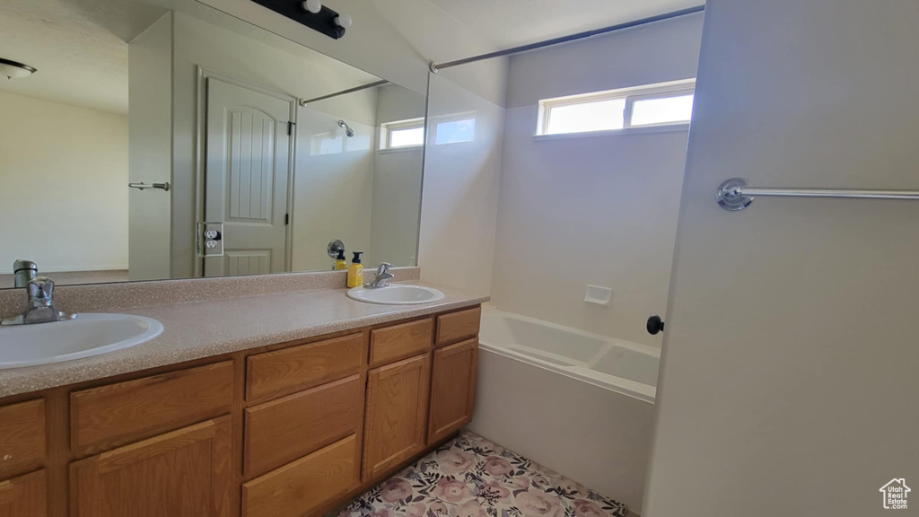 Bathroom with double vanity and bathing tub / shower combination